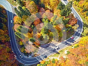 Autumnal landscape view of a mountain road and some cars passing by