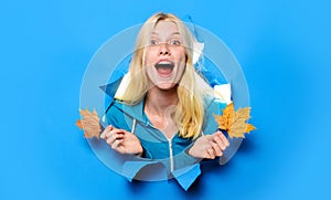 Autumnal mood. Smiling girl with maple leaves looking through paper hole. Autumn sale. Discount.