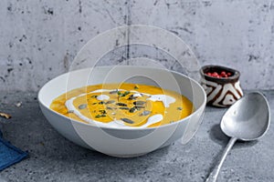 Autumnal soup in bowl on grey background