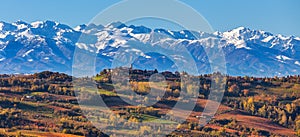 Autumnal vineyards and snowy mountains in Italy.