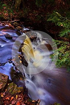 Autumnal Waterfall in Forest with Silky Water Flow