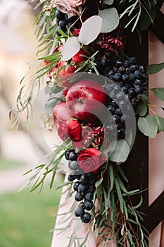 Autumnal wedding composition of roses, apples, grape and pomergranate