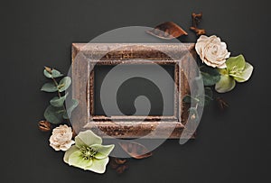 Autumnal-winter composition with vintage frame, dried leaves, bark of trees and berries on dark background.  Flat lay, copy space