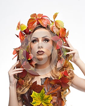 Autumnal woman. Beautiful creative makeup and hair style in fall concept studio shot. Beauty fashion model girl with fall makeup