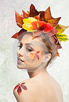 Autumnal woman. Beautiful creative makeup and hair style in fall concept studio shot. Beauty fashion model girl with fall makeup