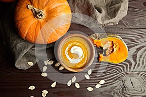 Autunm flat lay composition with pumpkin cream soup and fresh pumpkins