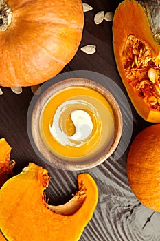 Autunm flat lay. Pumpkin soup in bowl and fresh pumpkins