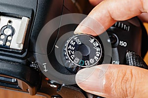 Av dial mode on dslr camera with fingers on the dial