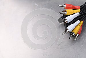 AV TV RCA composite audio-video cables on a gray metal background.Place for text.