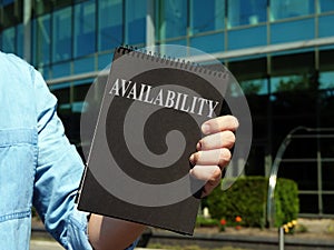 Availability. A man holding a notebook with the inscription.
