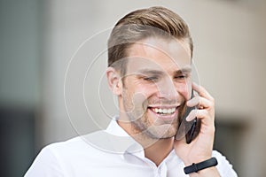 Always available. Man well groomed white shirt speak phone urban background. Guy handsome attractive office worker speak
