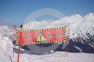 Avalanche danger sign in snow, winter mountains