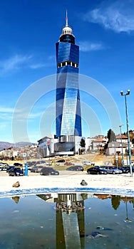 Avaz Tower in glass facade and antena in Sarajevo, reflection of tower in the fountain