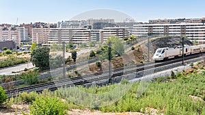 Ave high-speed train as it passes through the new neighborhoods of the city of Tres Cantos in Madrid.