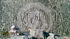 AVE MARIA engraved on a stone, lantern in the foreground.