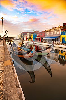 Aveiro, Portugal, Traditional colorful Moliceiro boats docked in the water canal among historical buildings.