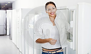 Average female customer looking at modern fridges