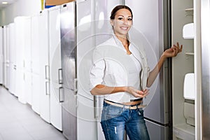 Average female customer looking at modern fridges