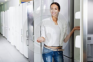 Average female customer looking at modern fridges