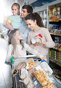 Parents with two little kids holding purchases in store