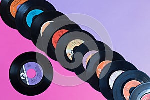 Avetrana, Italy, April 22, 2019 Old vinyl records on a two-color background: pink and lilac, retro concept, pop culture