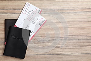 Avia tickets and passports on wooden table, flat lay with space for text. Travel agency concept