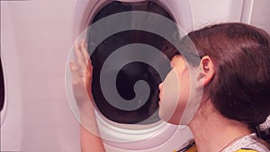 Aviation aircraft concept. young young girl looks out the airplane sitting by the window. flight at lifestyle night by