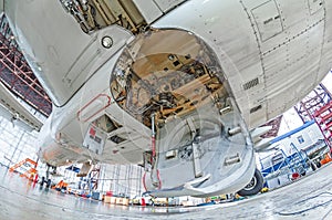 Aviation hangar with airplane, close-up landing gear of the airplane landing gear on maintenance repair.