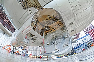 Aviation hangar with airplane, close-up landing gear of the airplane landing gear on maintenance repair. photo
