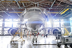 Aviation hangar with passenger aircraft jet for maintenance. Bright lights lighting, glare