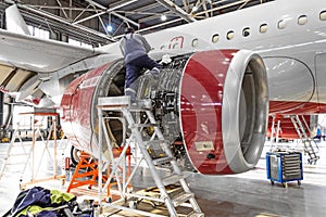 Aviation industry, mechanic repairs aircraft engine jet photo