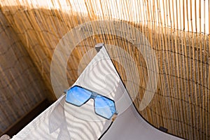 Aviator Sunglasses model for men with big blue lens reflecting the sun. Selective focus