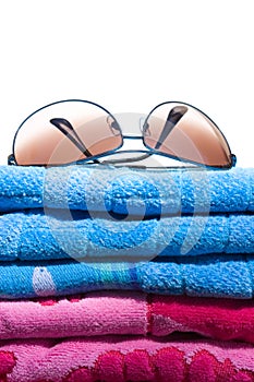 Aviator sunglasses on a stack of beach towels