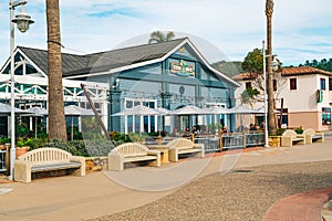 Avila Beach city promenade filled with restaurants, shops, patios, benches, and art