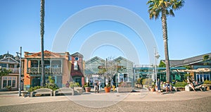 Avila Beach city promenade filled with restaurants, shops, patios, benches, and art