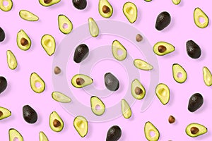 Avocado. Background made from isolated Avocado pieces on pink background. Flat lay of fresh ripe avocados and avacado pieces