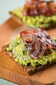 Avocado bacon on sunflower seed whole grain bread slice for breakfast or snack