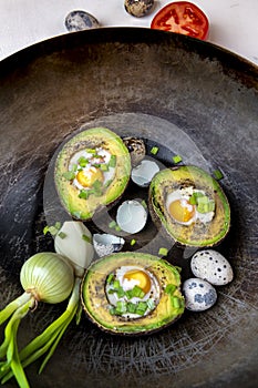 Avocado baked with quail eggs, fresh onion