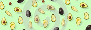 Avocado banner. Background made from isolated Avocado pieces on green background. Flat lay of fresh ripe avocados and avacado