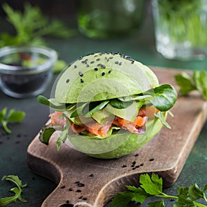 Avocado burger with salted salmon and fresh vegetables.