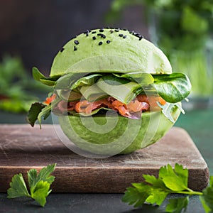 Avocado burger with salted salmon and fresh vegetables.