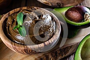 Avocado chocolate mousse in olive wooden bowl photo