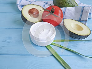avocado cream therapy on blue wooden tomato