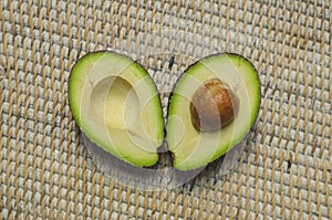 Avocado cut in half with seed in hand