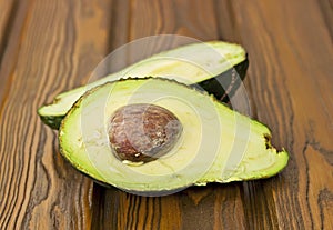 Avocado, cut in half, on the wooden table