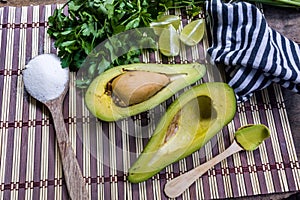 Avocado cut in halves accompanied by salt and lemon