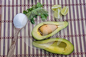 Avocado cut in halves accompanied by salt and lemon
