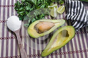 Avocado cut in halves accompanied by salt and lemon.