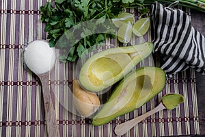 Avocado cut in halves accompanied by salt and lemon.