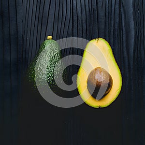 Avocado displayed on dark wooden background, creating striking contrast